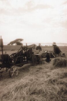 Photograph of people operating a baler