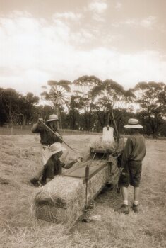 Photograph of people operating a baler