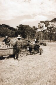Photograph of people operating a baler