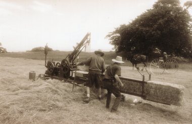 Photograph of a group of people baling hay