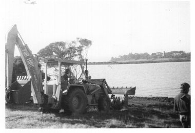 Photograph of excavator next to a shoreline