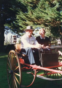 Photograph of two people in a buggy