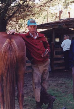 Photograph of man preparing to shoe a horse