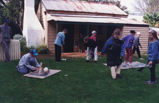 Photograph of group of people playing games in front of Rogers Cottage