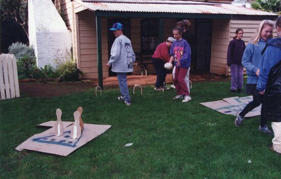 Photograph of group of people playing games in front of Rogers Cottage