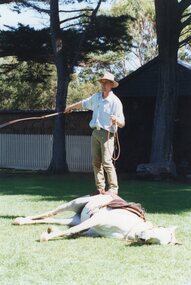 Photograph of man and a horse lying down