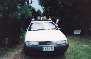 Photograph of a white car with lights on the top