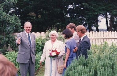 Photograph of five people standing in a garden