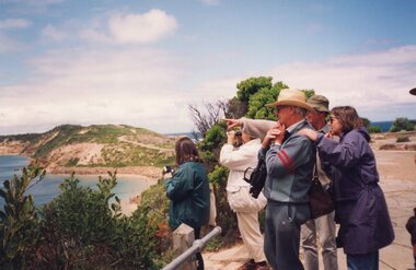 Photograph of people looking over shoreline