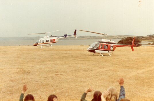 Photograph of two helicopters taking off