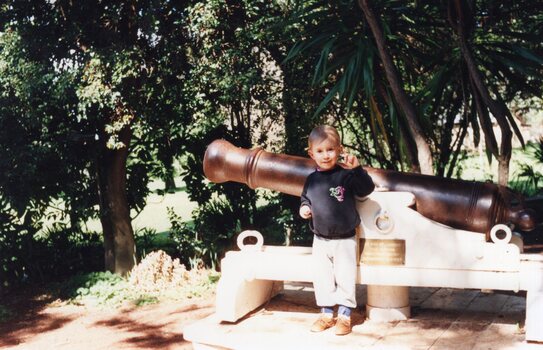 Photograph of child in front of cannon