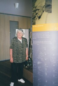 Photograph of woman standing beside display text