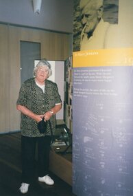 Photograph of woman standing beside display text