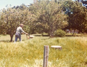 Photograph of a man mowing