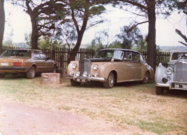 a photograph of three parked cars