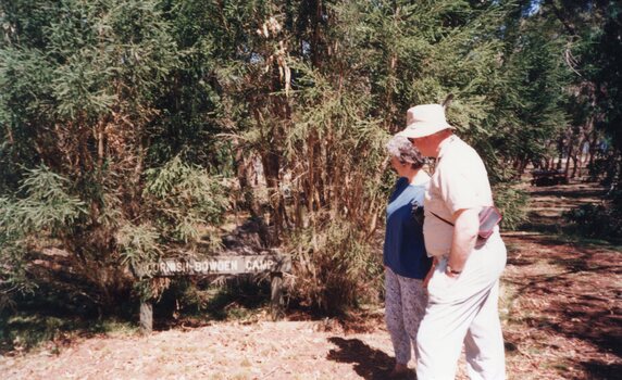 Photograph of two people looking at a sign