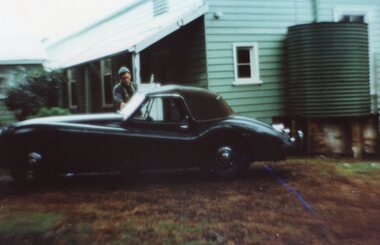 Photograph of man getting into car