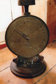 brass dial-faced scales sitting on wood bench
