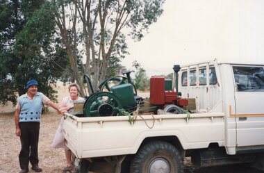 Photograph of two people and a ute