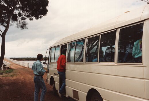 Photograph of people boarding a minibus
