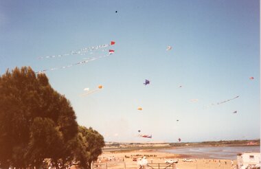 Photograph of kites flying above a beach