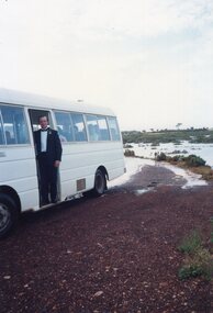 Photograph of man standing at minibus door