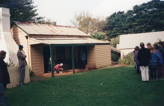 Photograph of people standing around Rogers Cottage