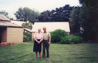 Photograph of two people in front of Rogers' Cottage