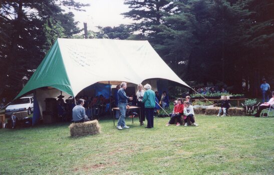 Colour photograph of people gathered around a marquee