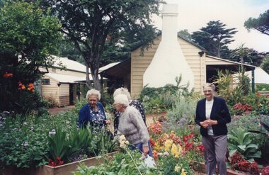 Colour photograph of four women walking in the gardens