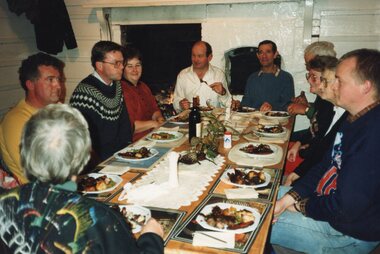 Colour photograph of a group seated at dinner
