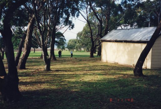 Colour photograph of a shed and two people
