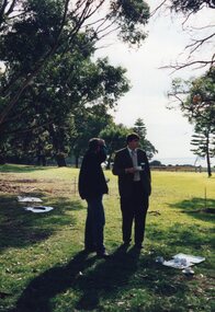 Photograph of two people standing on grass