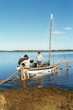 Photograph of people and sailboat