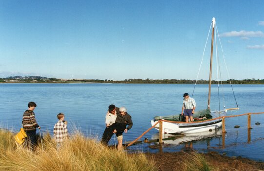 Photograph of people and sailboat