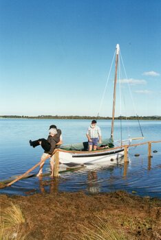 Photograph of people and sailboat