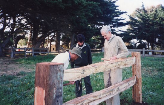 Photograph of men and fence