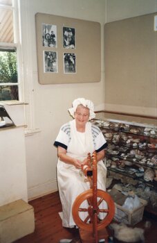 Photograph of woman spinning wool