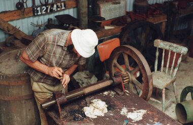 a photograph of man blacksmithing