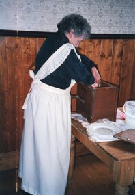 Photograph of woman making butter