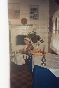 Colour photograph of woman sitting in chair