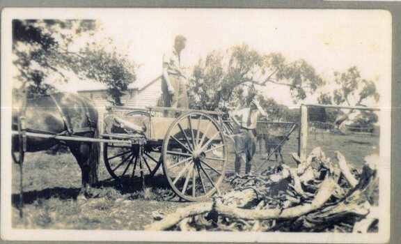 Photograph of two people, horse, and cart