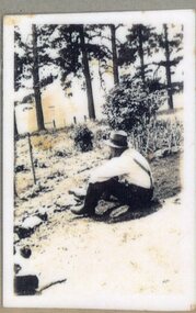 Photograph of man sitting on ground
