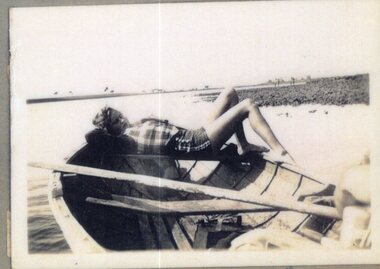 Photograph of woman lying in a boat