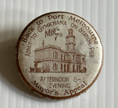 Round metal badge with photo of Port Melbourne Town Hall and details of the Gymkhana