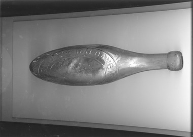 Glass bottle with round pointed bottom and moulded lettering.