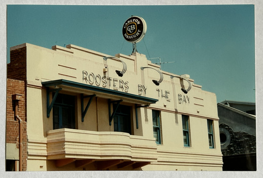 Upper storey of a hotel with an Art Deco-style balcony, Roosters by the Bay.