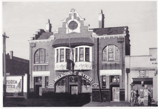 Front view of an ornate two storey building with "Melbourne Bitter" written in large letters above the door.