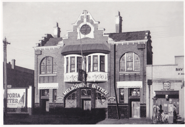 Front view of an ornate two storey building with "Melbourne Bitter" written in large letters above the door.