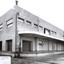 A substantial two storey brick building viewed at an angle with a loading dock along the longer side of the building.